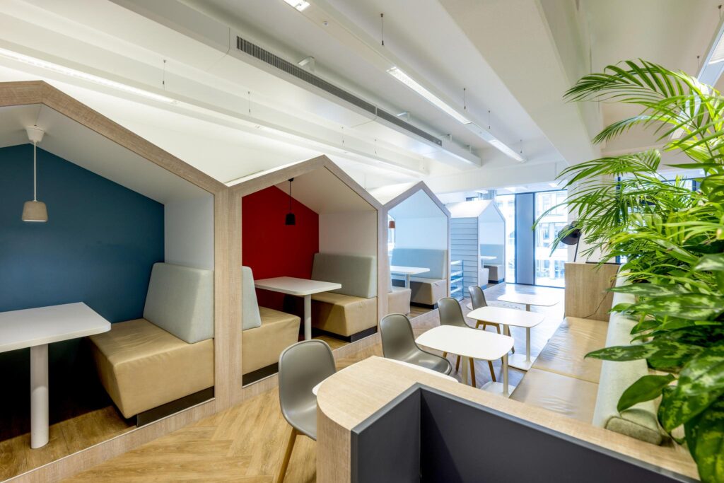 Modern seating area with house-shaped booths and tables at Mr. Treublaan office.
